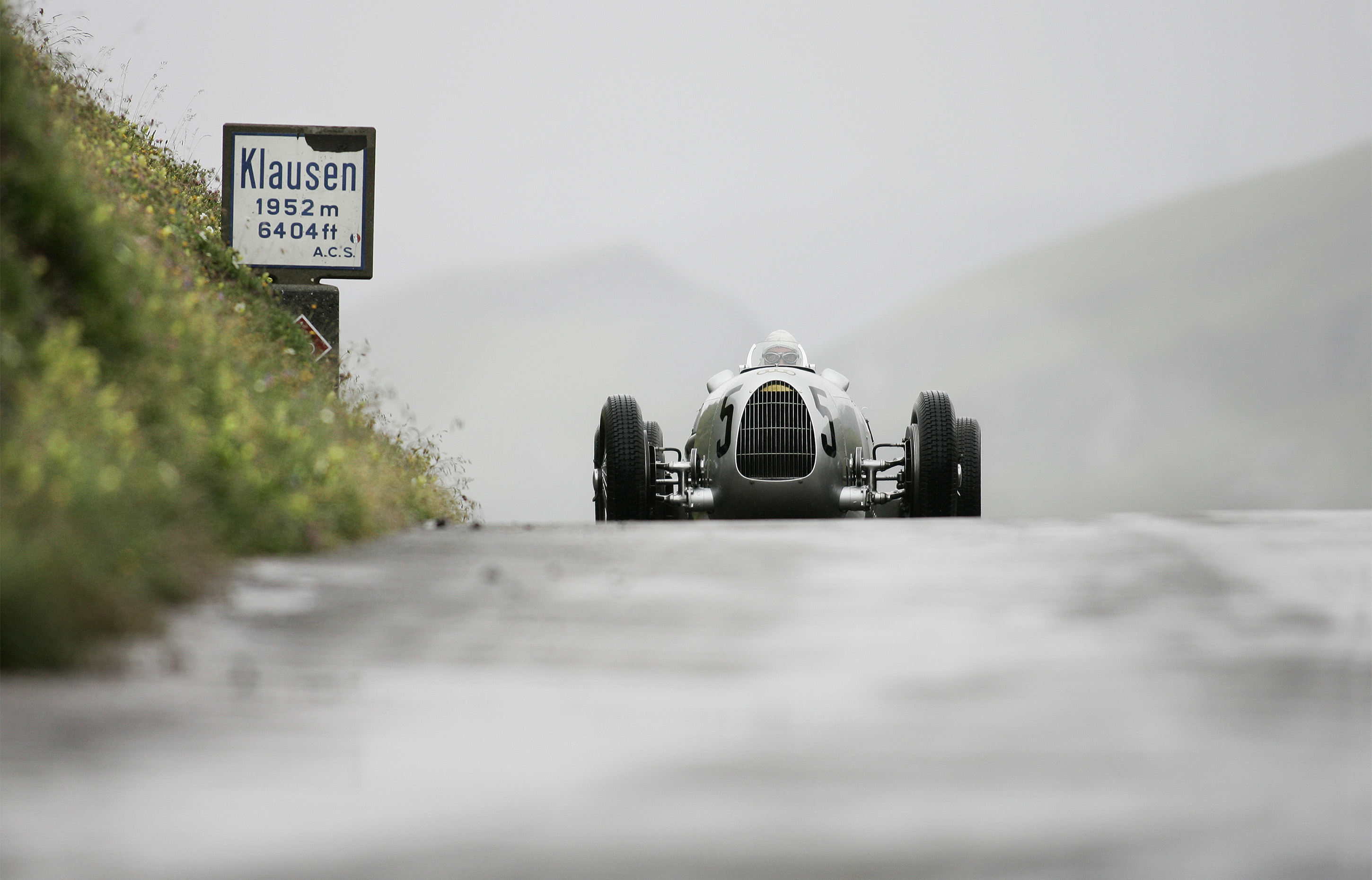 Klausen Pass, Switzerland - Classic 1937 Auto Union C-type races the Klausen Pass, Switzerland. The best racers in the world came together every year from 1922 to 1934 to race the Klausen Pass. Past performances by historic racers included Caracciola, Stuck, Nuvolari, and Chiron.